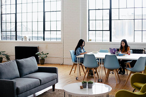Woman working on a laptop in a bright, modern living room.